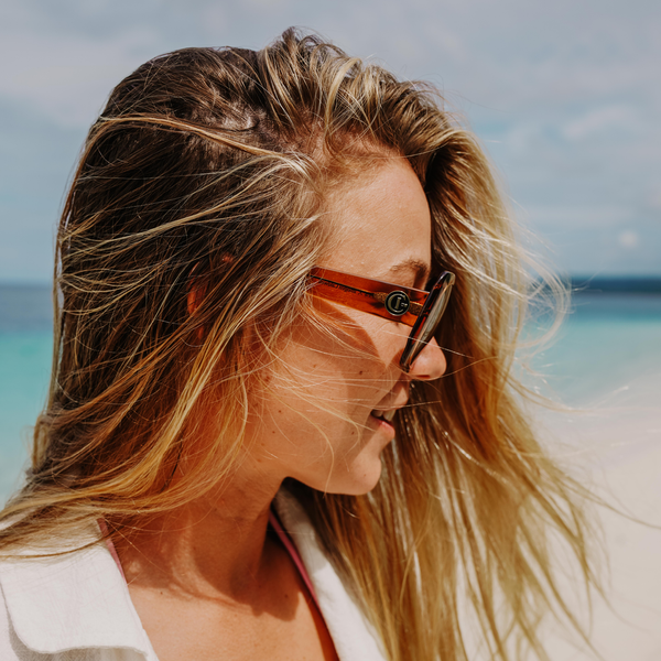 Imogen Caldwell at the beach wearing oversized sunglasses and looking to the side
