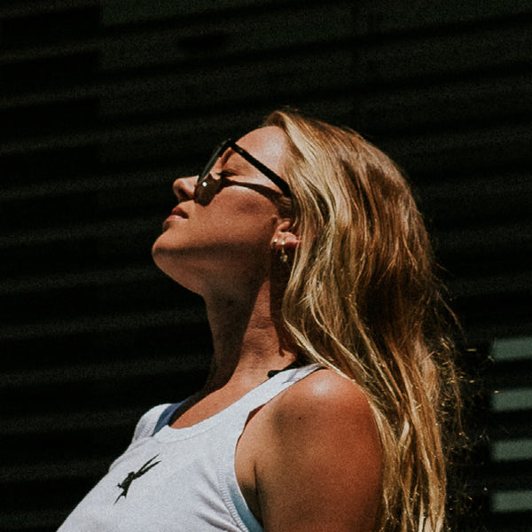 Imogen Caldwell wearing scratch resistant sunglasses looking up