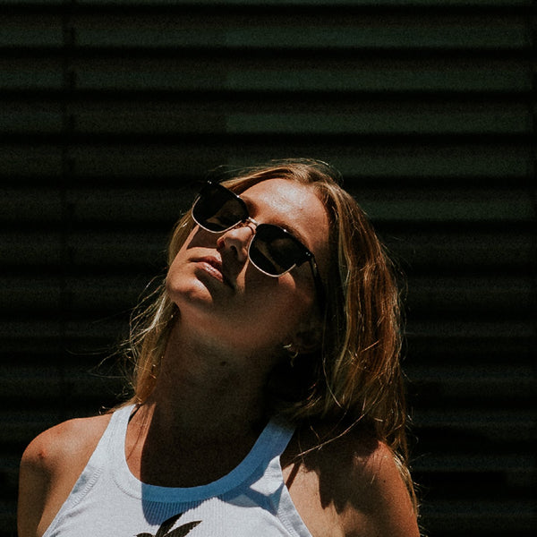 Woman wearing scratch resistant sunglasses looking up
