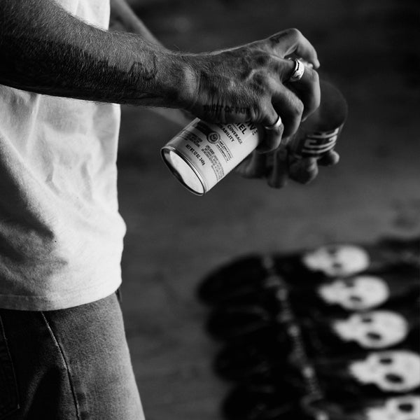 Jamie Thomas spray painting skateboards on the ground