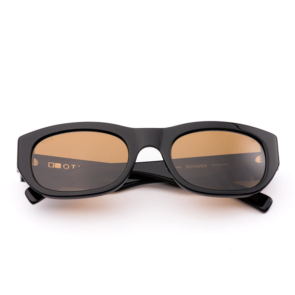 Black sunglasses with brown lenses on a white background