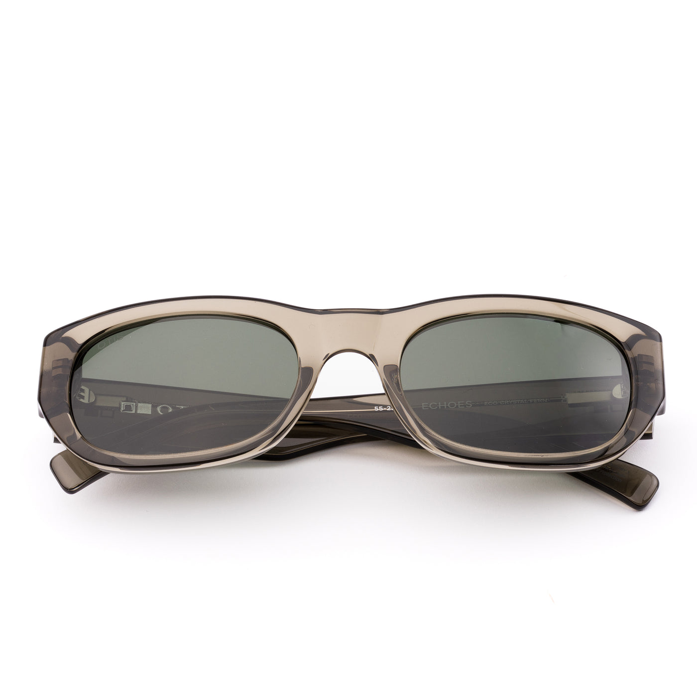 Sunglasses with a green transparent frame and dark lenses on a white background