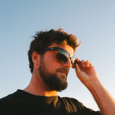 Man wearing a black shirt and square sunglases