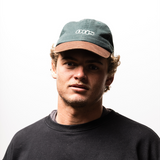 Man wearing a cap and black shirt against a white background