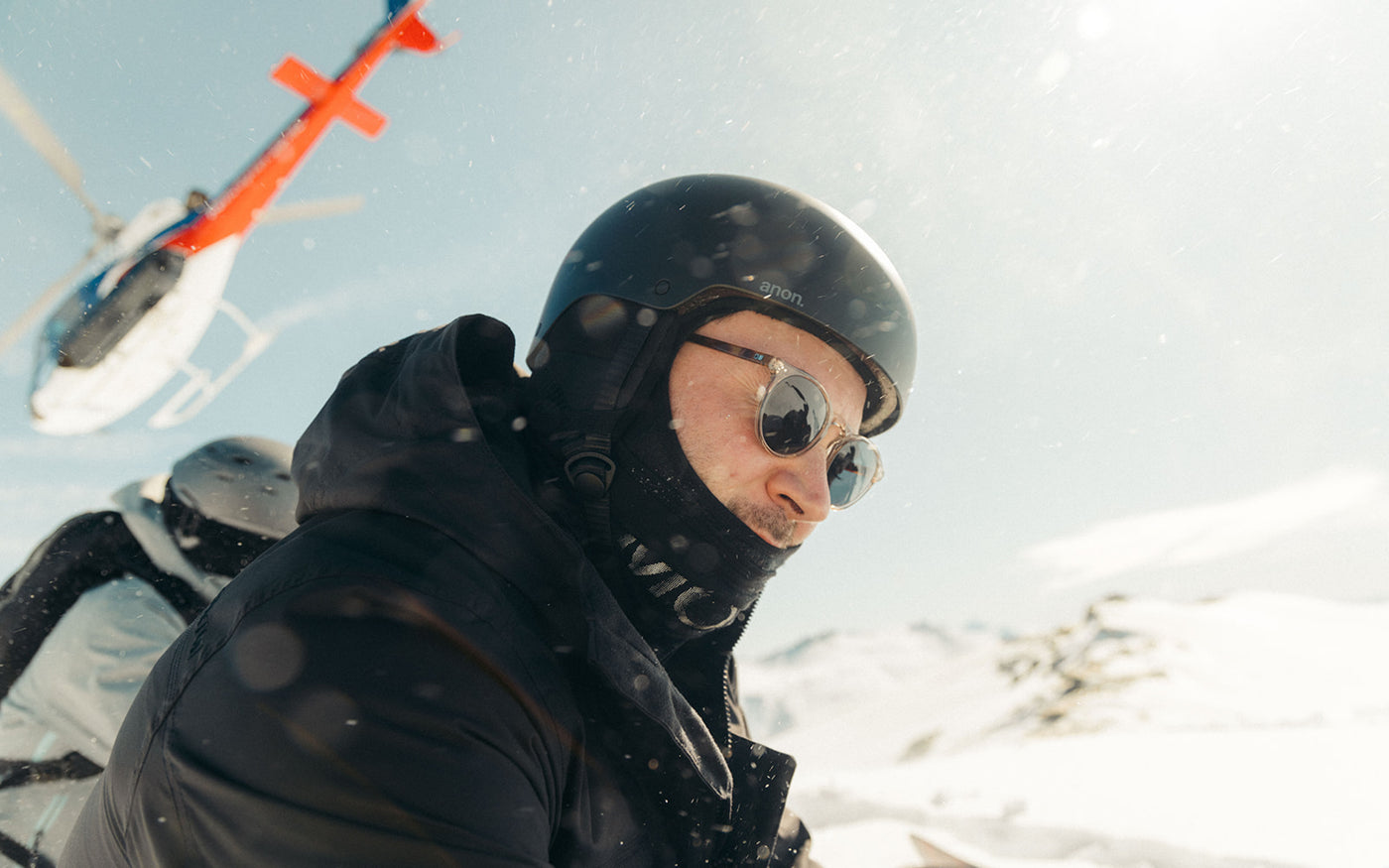 Man with a helmet on in a snow storm wearing OTIS eyewear scratch resistant sunglasses