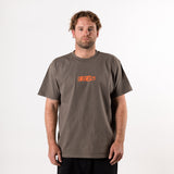 Man wearing a brown t-shirt with an orange OTIS logo on a white background
