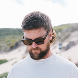 Man wearing sunglasses with a scenic background