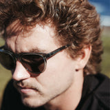 Man wearing crystal blue sunglasses looking to the side