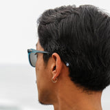 Kentaro Yoshida looking out to the ocean wearing blue sunglases
