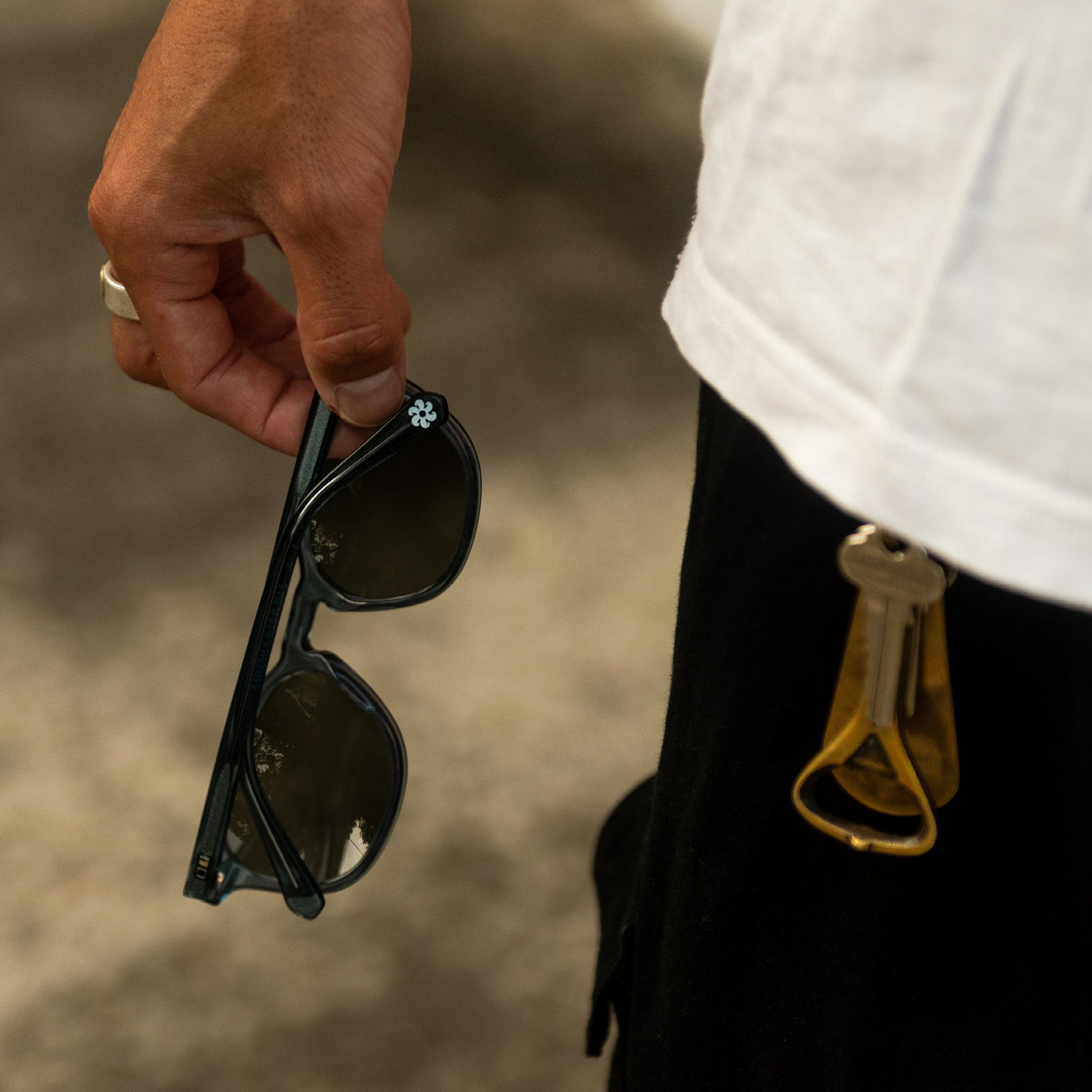 Hand holding blue mineral glass sunglasses
