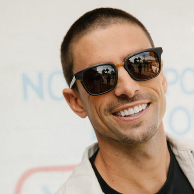 Man smiling wearing brown and gold sunglasses
