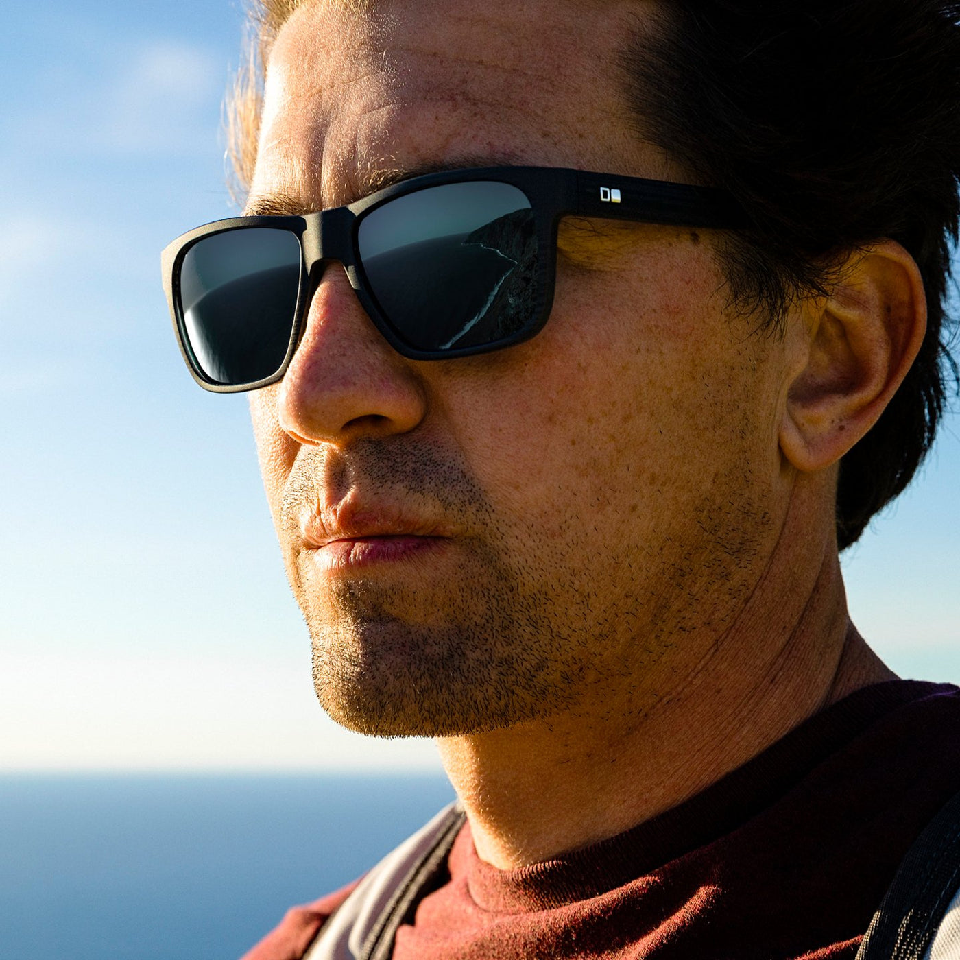 Greg Long wearing sunglasses looking out into the distance over the ocean.