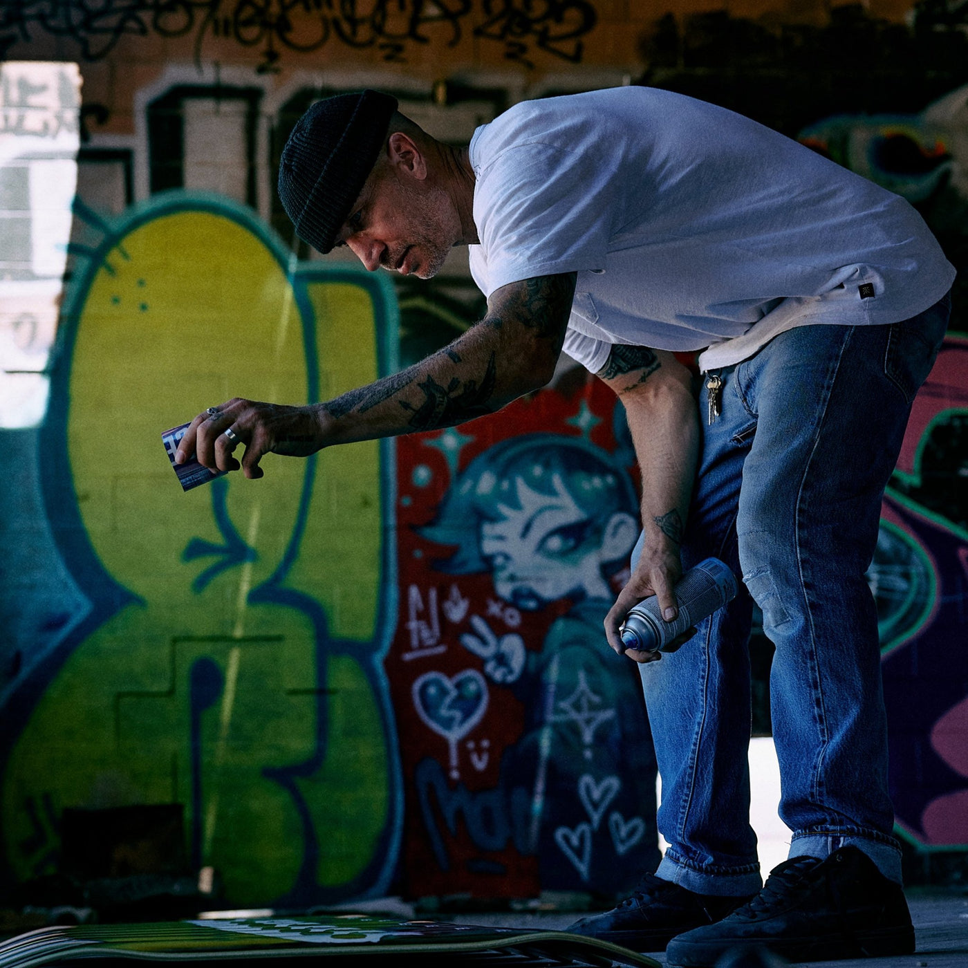Jamie Thomas splashing paint onto a skateboard on the ground