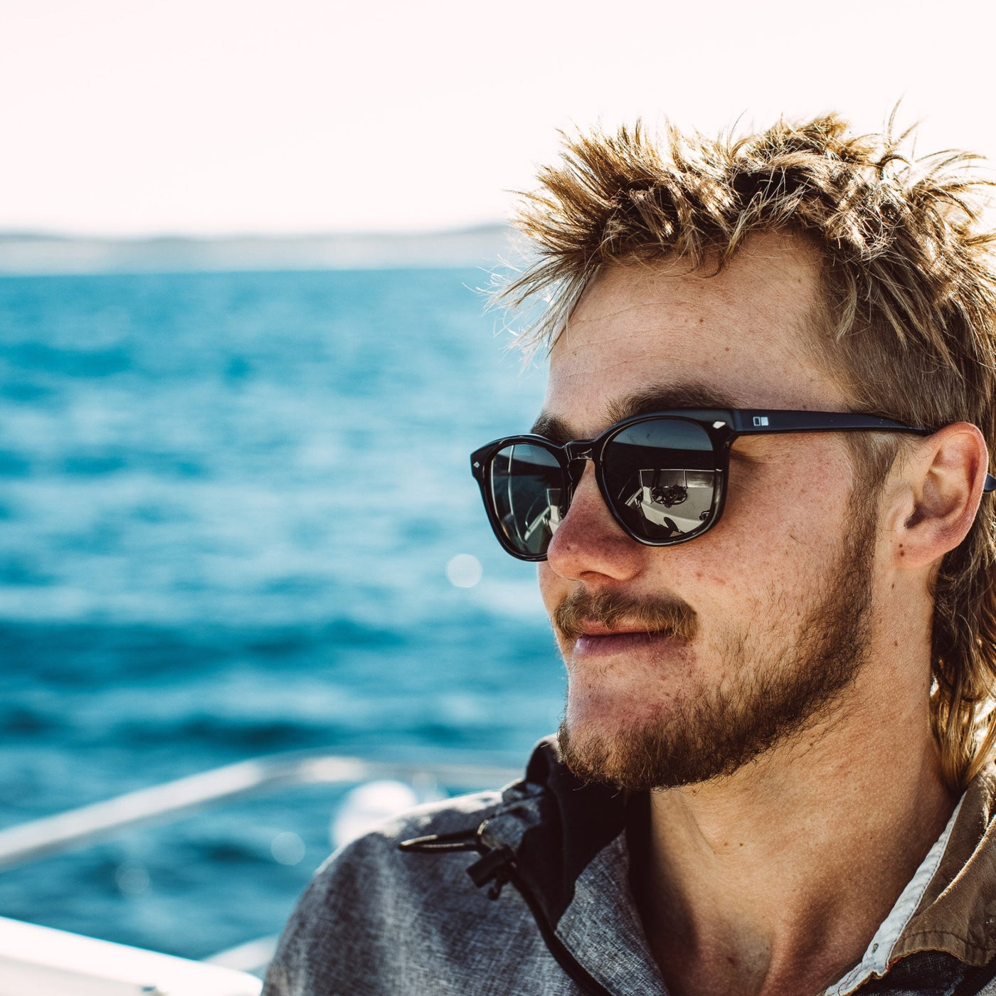 Cray fisherman wearing OTIS Eyewear black scratch resistant glasses on a boat and smiling